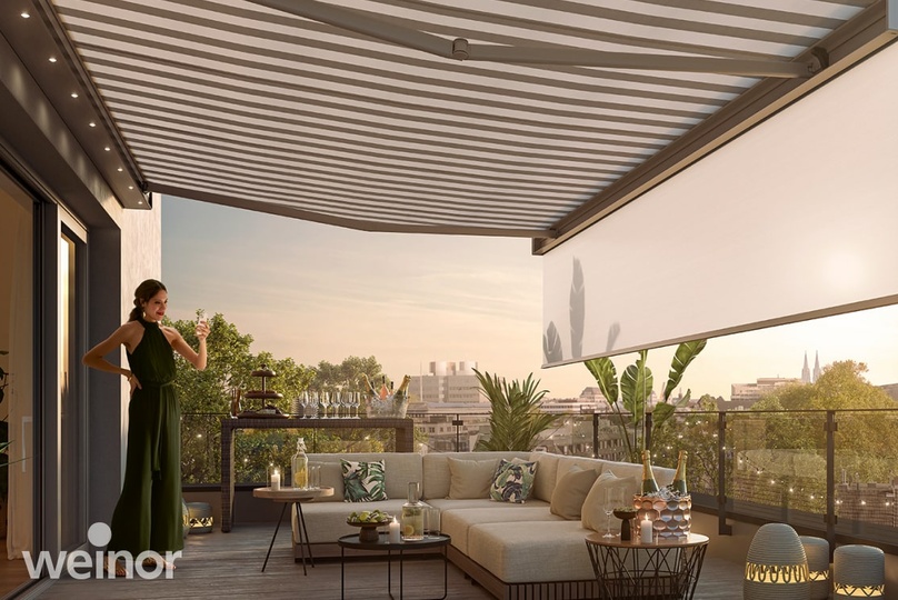 Frau auf Terrasse mit ausgefahrener Markise am Abend