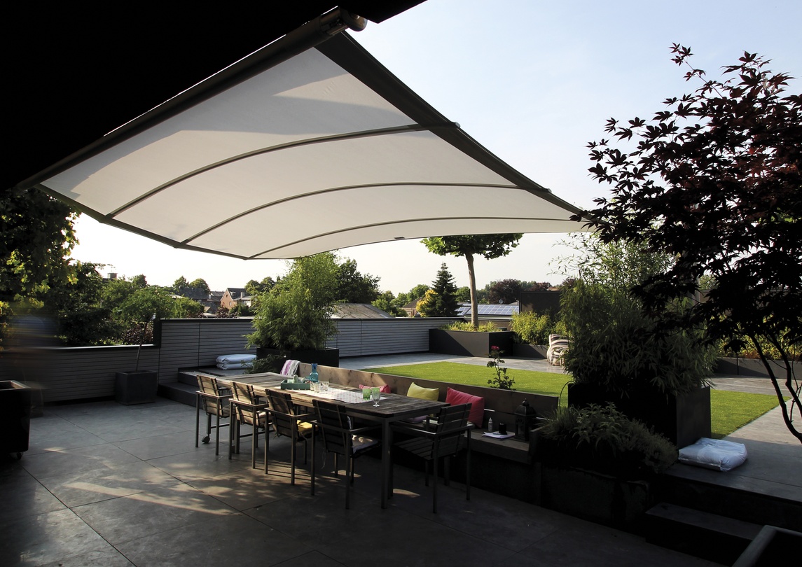 Moderne Terrasse mit weißer Markise, Esstisch und Garten im Sonnenlicht.