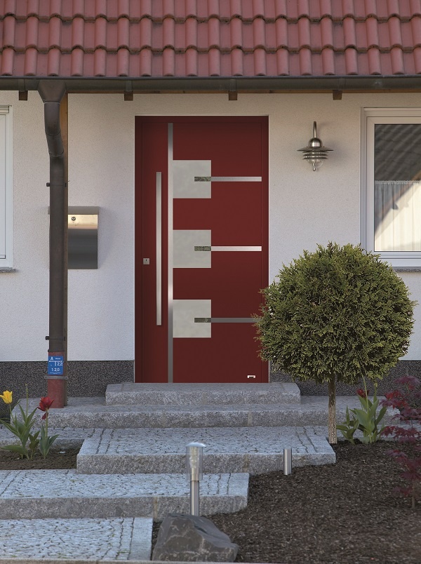 Moderne rote Haustür mit silbernen Griffen und grauen Dekorelementen. Steinstufen führen dazu.
