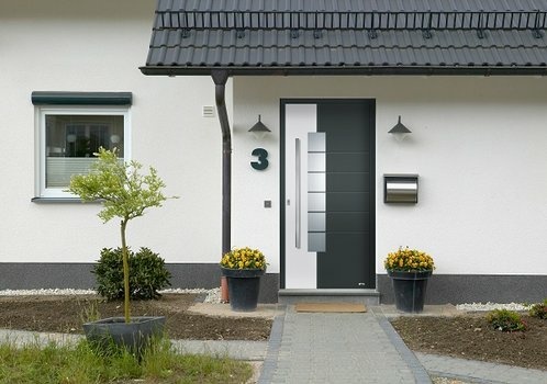 Fotografie: Moderner Hauseingang mit zweifarbiger Tür, gelben Blumen und grauem Dach.