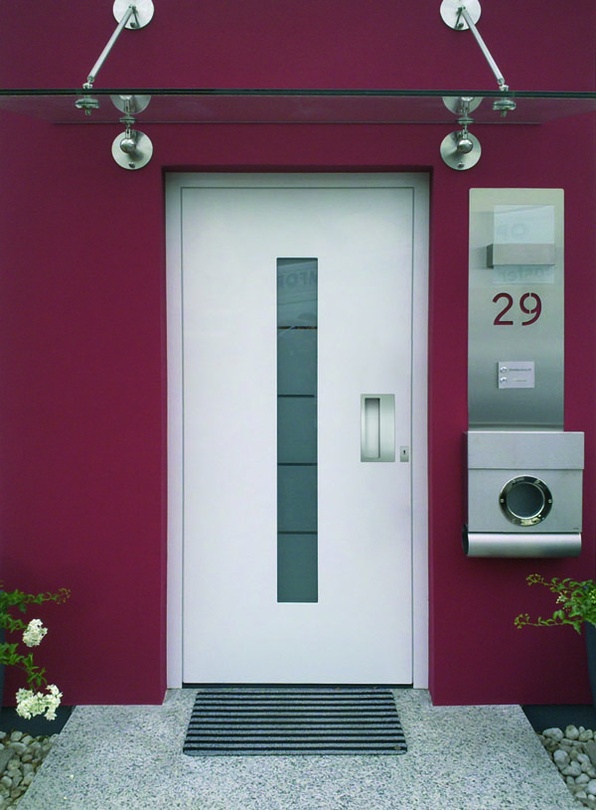 Moderne weiße Haustür mit Glasausschnitt in purpurroter Wand, Nr. 29 und Briefkasten rechts.