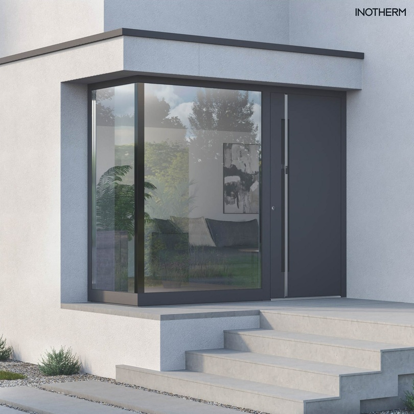 Moderner Hauseingang mit großem Eckfenster, dunkelgrauer Tür und Betontreppe.