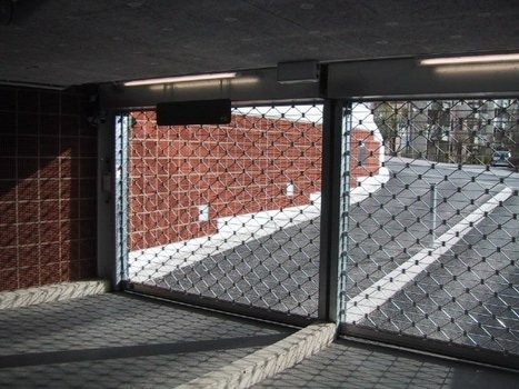 Offenes Rollgittertor einer Tiefgarage mit Blick auf eine Straße.