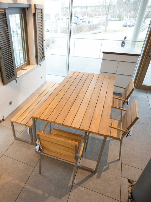 Modernes Ess-Set aus Holz und Metall mit Tisch, Bank und zwei Stühlen in hellem Raum.