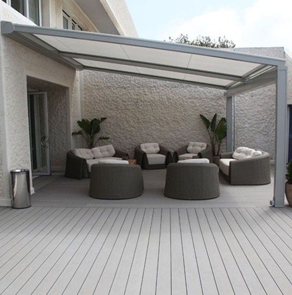 Moderne Terrasse mit grauem Sonnenschutz und Loungemöbeln.
