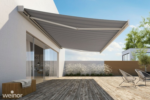 Großflächige Terrasse mit ausgefahrener Markise in dunklem Grau
