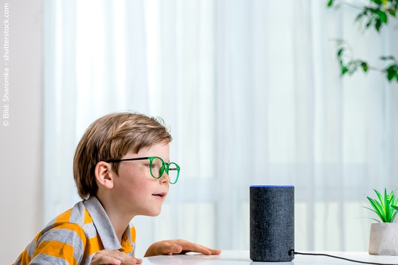 Kleiner Junge spricht mit einem smarten Alexa Lautsprecher