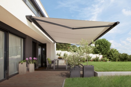 Moderne Terrasse mit ausgefahrener Markise, Gartenmöbeln und Pflanzen.